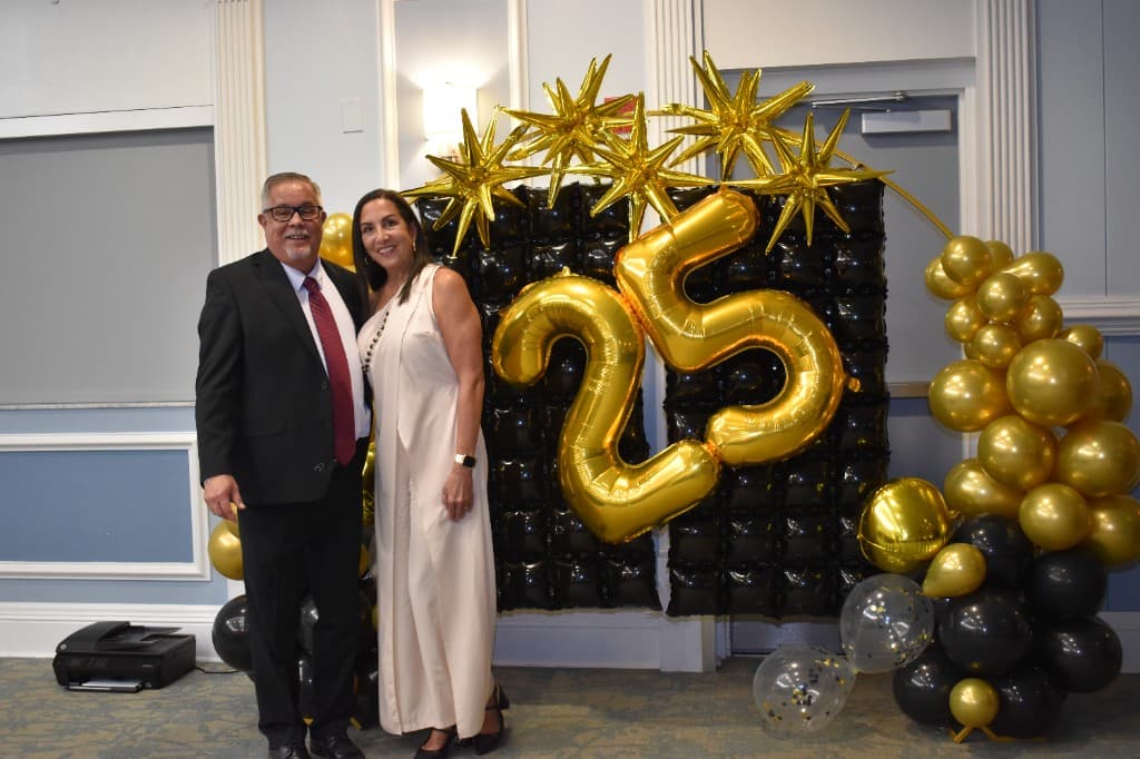 Guests celebrating at the HHI 25th anniversary balloon display