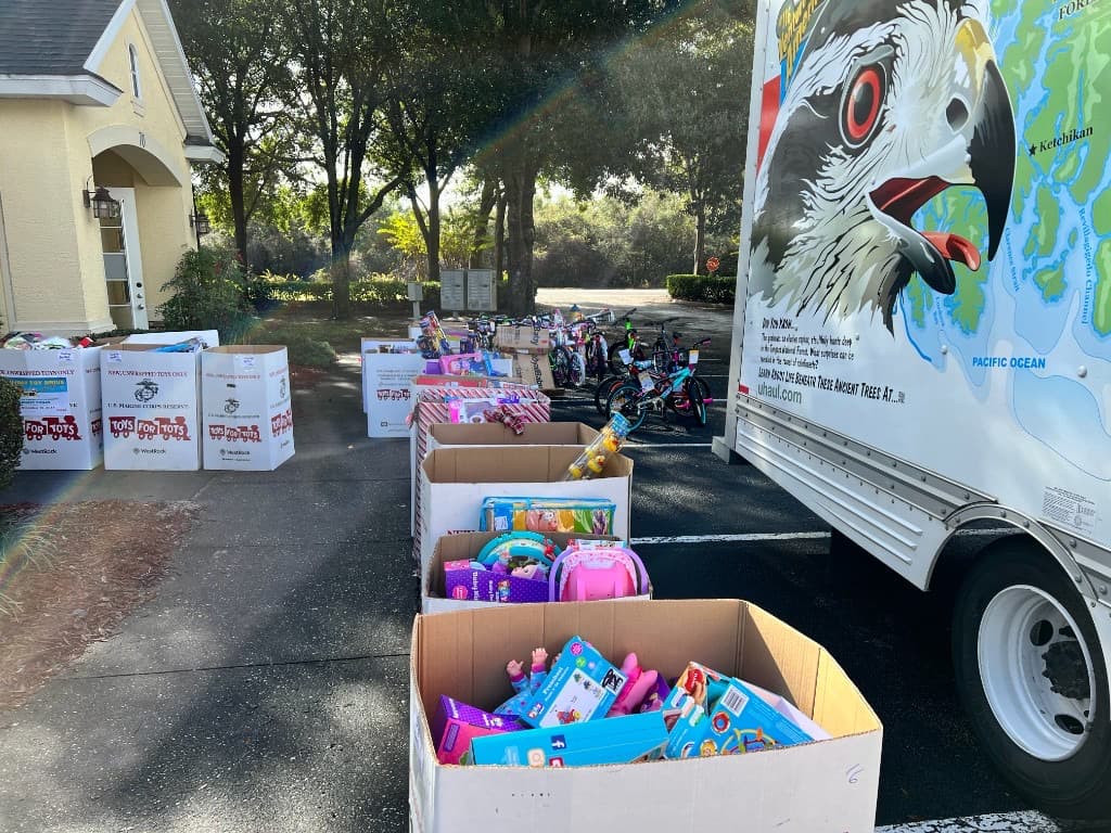 Rows of Toys for Tots collection boxes and children's bicycles outside the HHI office