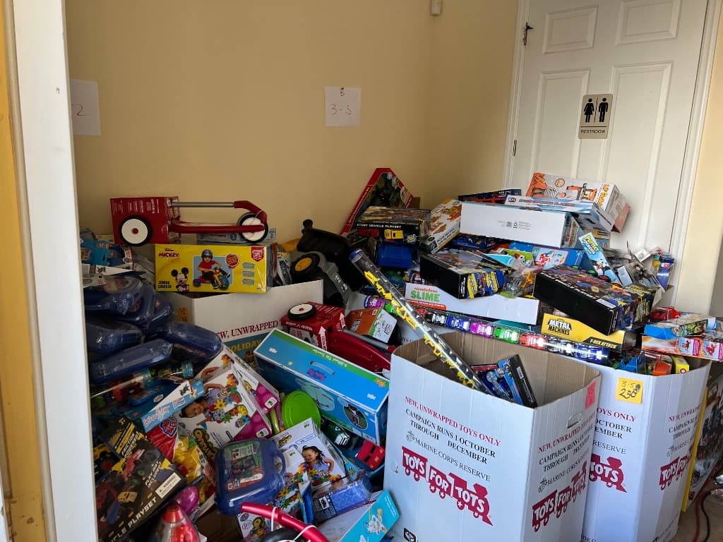Families and volunteers gathered around Toys for Tots donation boxes during the holiday drive