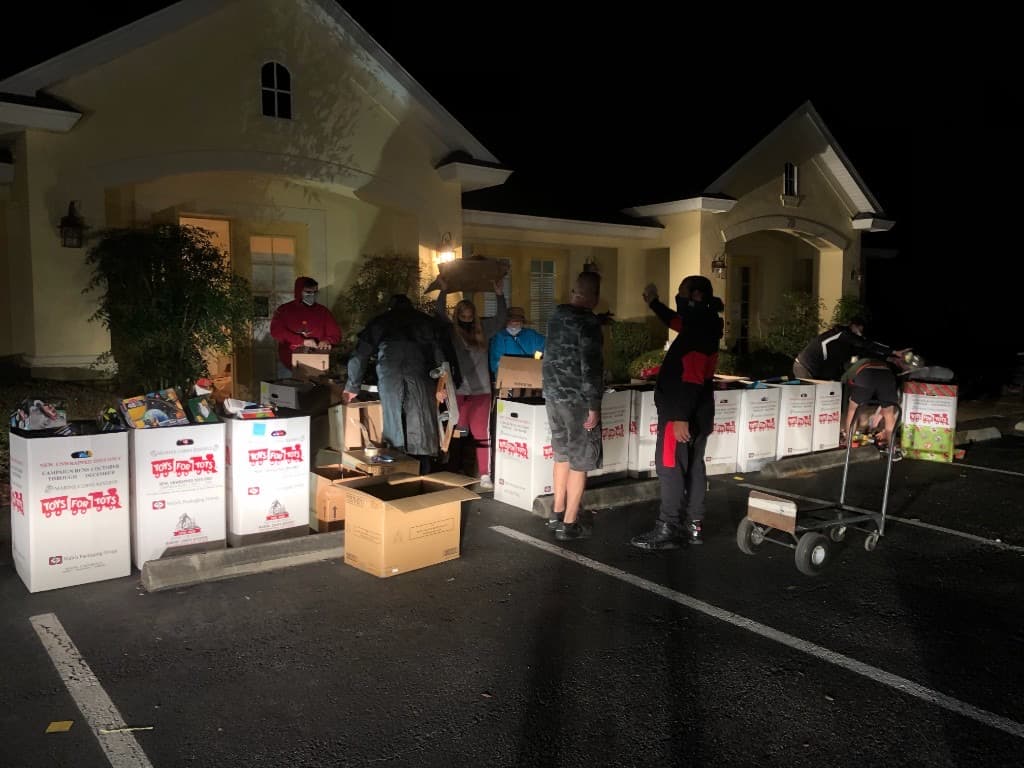 Parking lot display of bicycles, candy donations, and grocery bags for families in need