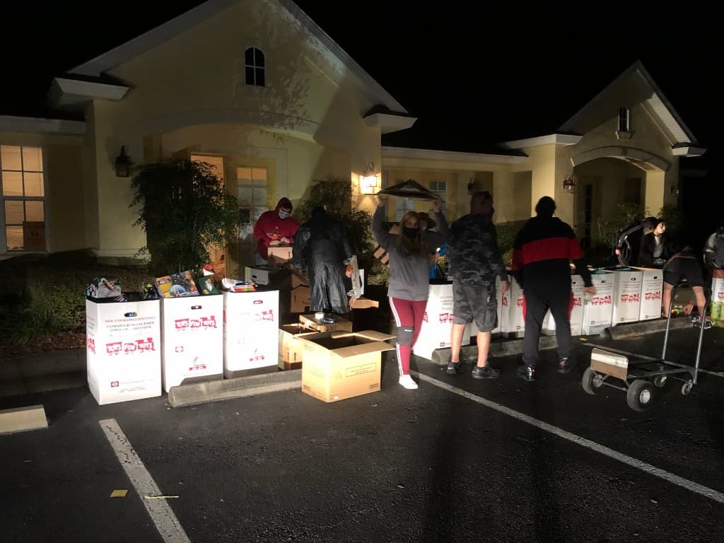 Toys for Tots donation boxes and bicycles staged beside a U-Haul truck for transport