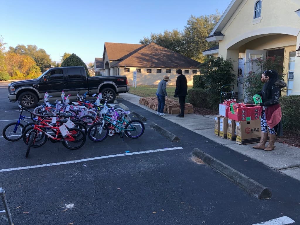 Volunteers and Santa Claus beside a row of donated bicycles at the holiday toy drive
