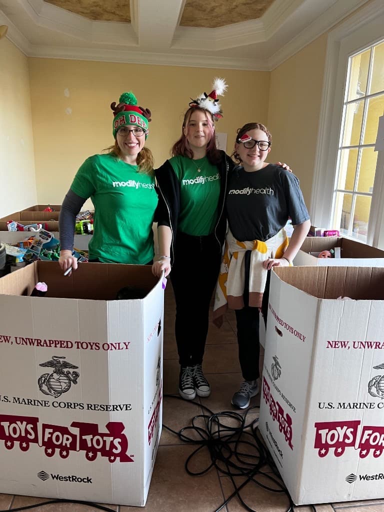 Community partners unloading toy donations beside rows of children's bicycles