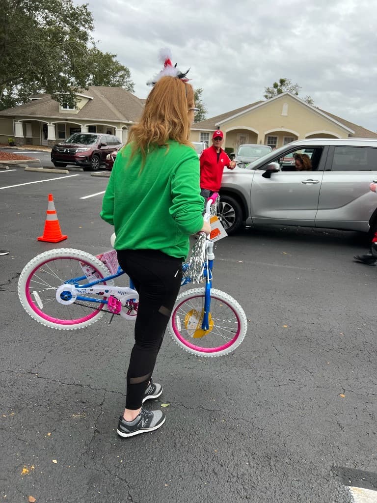 Wide view of donation boxes, bicycles, and volunteers during the holiday toy drive
