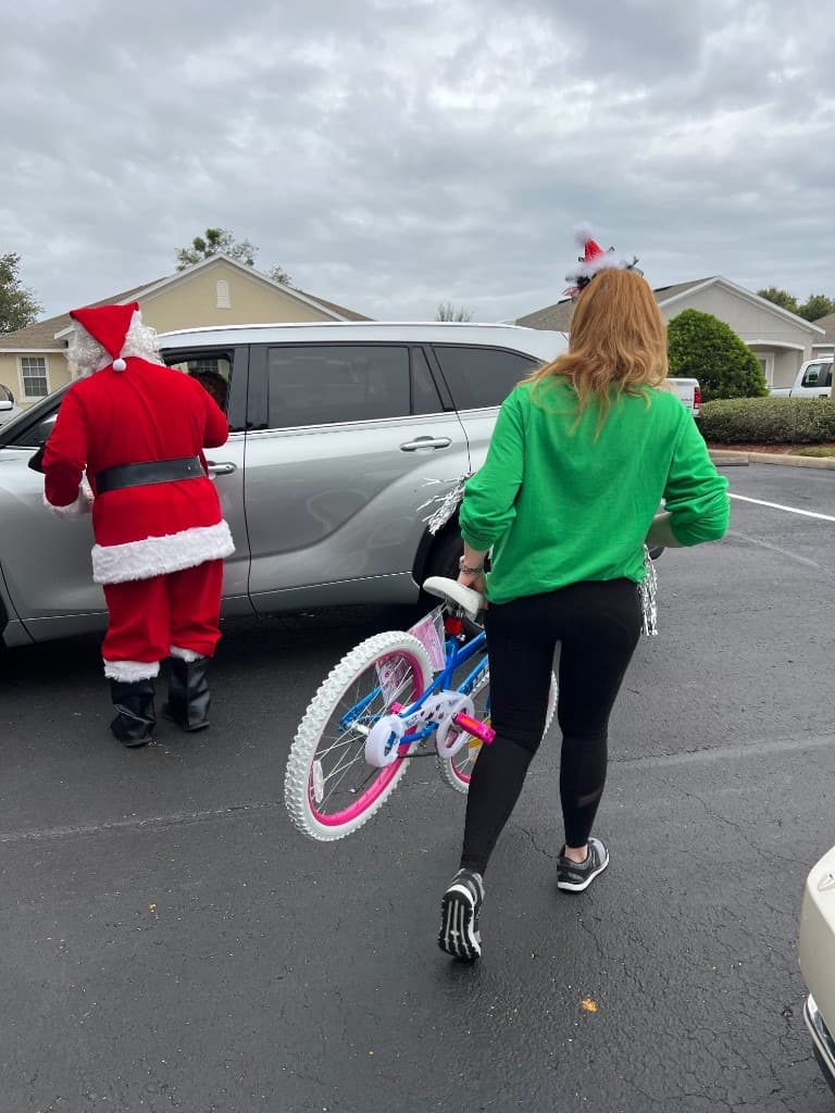 Volunteers in festive headbands preparing bicycles for families at Toys for Tots