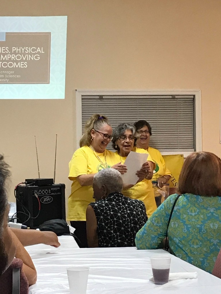 HHI advocates in yellow shirts sharing information during a community health workshop presentation