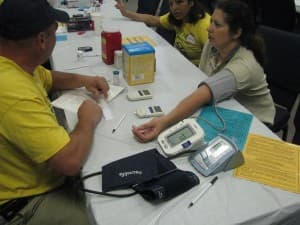HHI staff conducting a bilingual community health screening with Hispanic families at a Central Florida outreach event